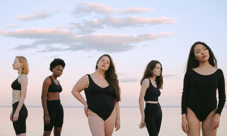Women standing against cloudy sky