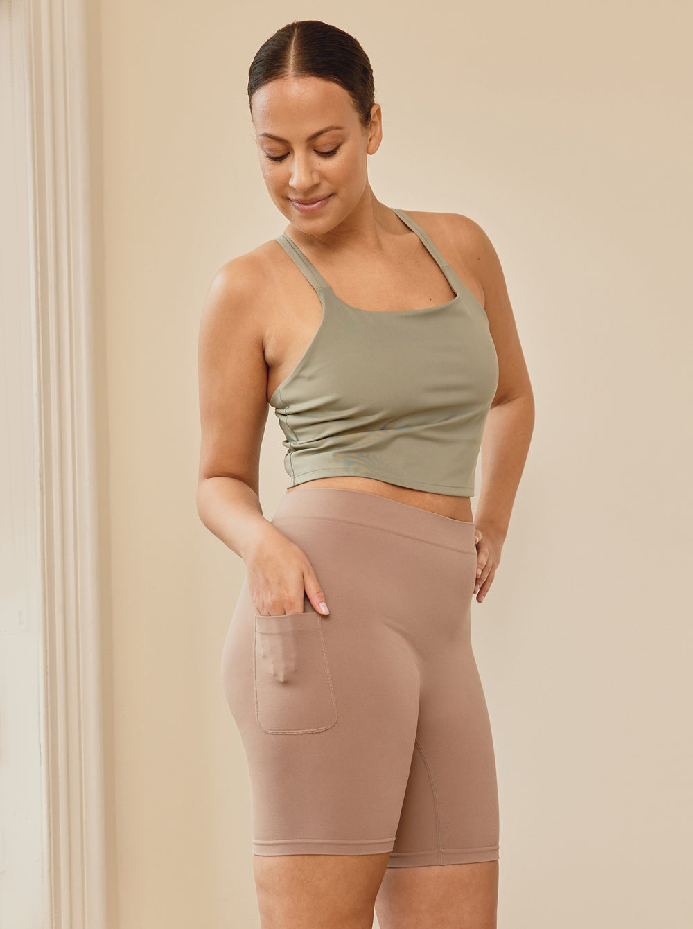 Side view of taupe Cargo 7-inch anti-chafe shorts on model showing cargo pocket and mid-thigh fit on neutral background