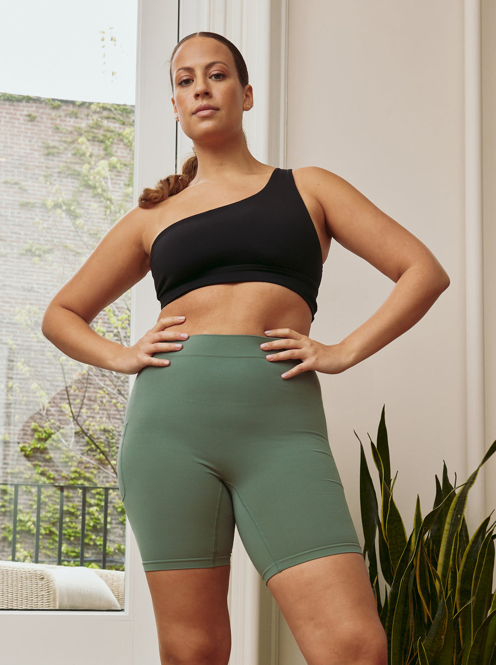 Front view of The Cargo 7-inch sage shorts on model with high-rise waistband, cargo pockets, and fitted length
