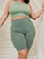 Front view of The Cargo 9-inch sage shorts showcasing side cargo pocket and high-rise fit on a model in a white stairwell