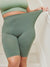Front close-up of The Cargo 9 inch sage shorts on a model showing high waistband, stretch, and mid-thigh length