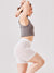 Side view of The Cooling 5-inch Halo shorts in white on model showcasing seamless snug mid-rise fit against light background