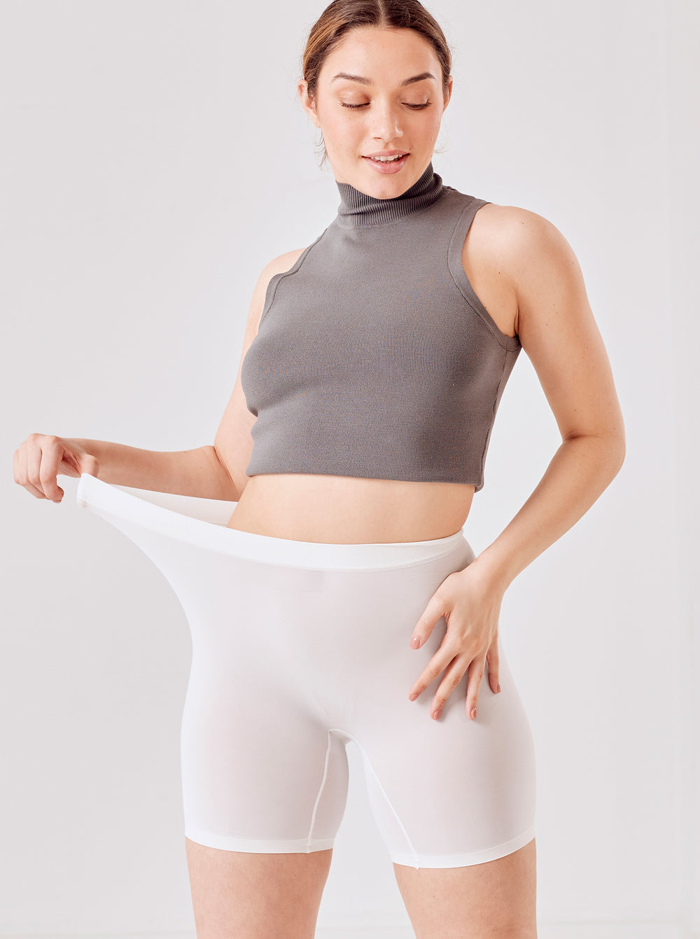 Front view of The Cooling 5-inch Halo shorts in white on model showing high-stretch waistband and mid-thigh fit against light background
