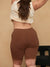 Rear view of 9-inch Cooling Anti-Chafe shorts in cocoa on a model, showing smooth fabric and mid-thigh coverage on beige background